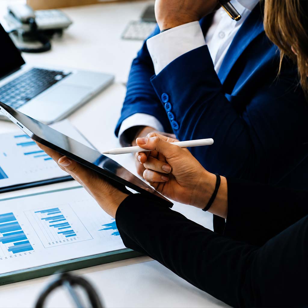 Profissionais em reunião analisando gráficos e planejando ações de negócios e sustentabilidade